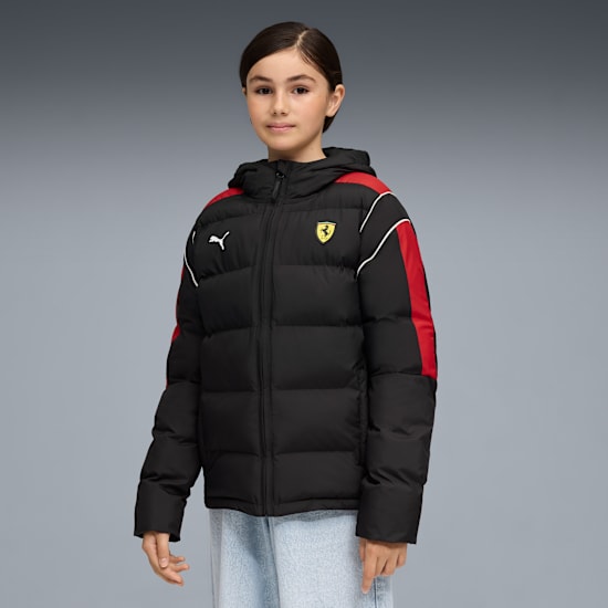 A model poses against a grey backdrop, wearing a black, red and white padded jacket.