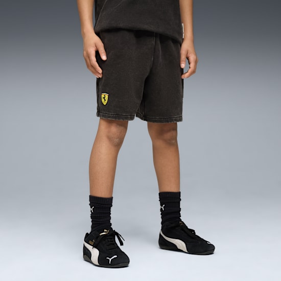 Un mannequin porte un short avec le logo Ferrari, des chaussettes noires et des baskets noires et blanches.
