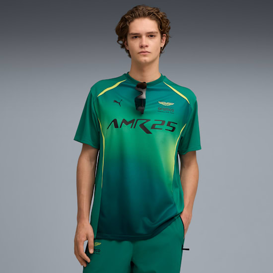 A model stands against a grey backdrop, wearing a green and yellow t-shirt and matching shorts.