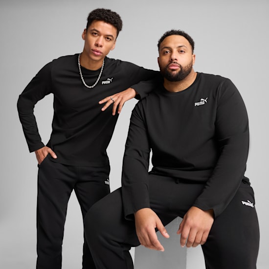 Twee modellen poseren tegen een grijze achtergrond, gekleed in bijpassende zwarte shirts met lange mouwen en broeken.