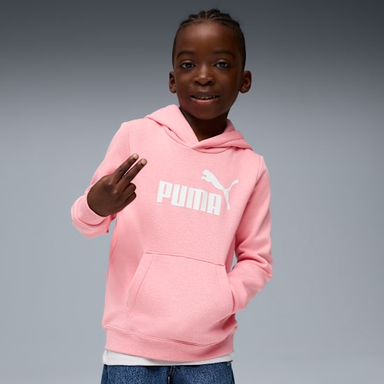 A child poses against grey, wearing a pink hoodie with a white Puma logo.