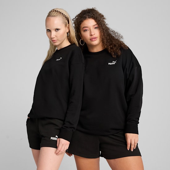 Zwei Models posieren vor grauem Hintergrund in schwarzen Sweatshirts und Shorts.