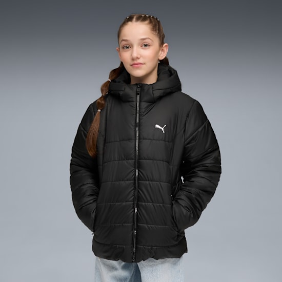 Ein Model posiert vor grauem Hintergrund und trägt eine schwarze Steppjacke mit Kapuze.