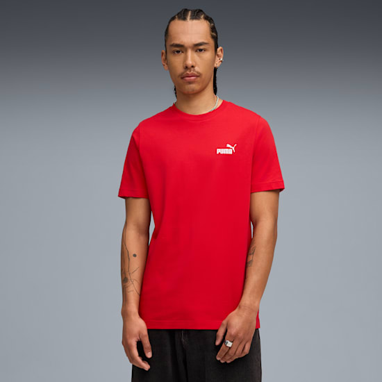 Een model staat tegen grijs, draagt een rood t-shirt met een wit logo.