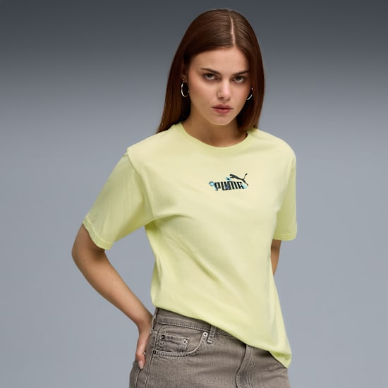 Model poses against grey, wearing a pale yellow Puma t-shirt and grey jeans.