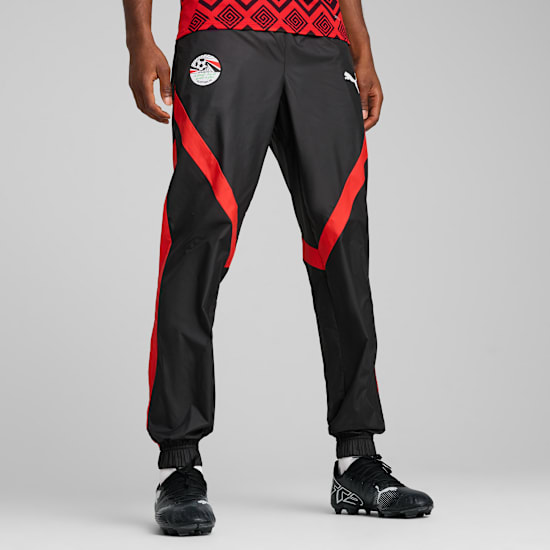 Modèle sur fond gris portant un pantalon de foot Égypte noir et rouge.