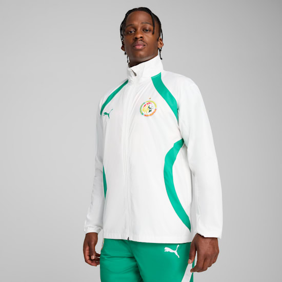 On grey, a model poses wearing a white and green jacket and green trousers.