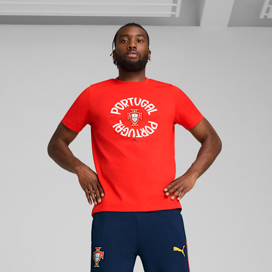 A model poses against a grey backdrop, wearing a red Portugal t-shirt and blue bottoms.