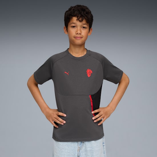 Een model poseert tegen een grijze achtergrond, met een grijs T-shirt en lichtblauwe broek.