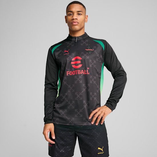 A model stands against a grey background wearing a patterned black long-sleeved top and shorts.