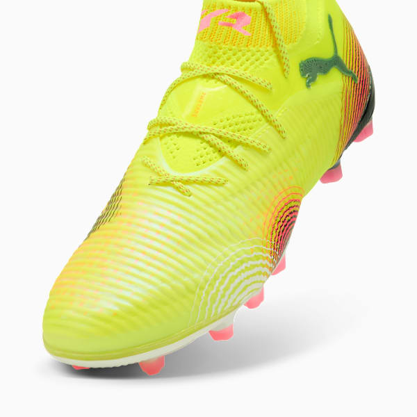 Yellow PUMA football boot, laced, with textured upper and pink stud details.