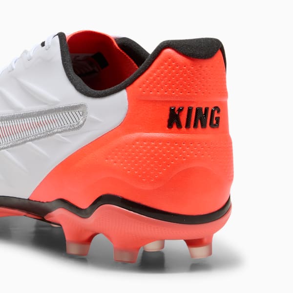 White and orange PUMA football boot displaying the word 'KING' on the heel.