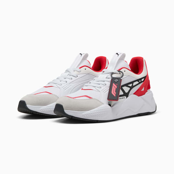 White PUMA unisex trainers with red and black accents, plus a branded tag.
