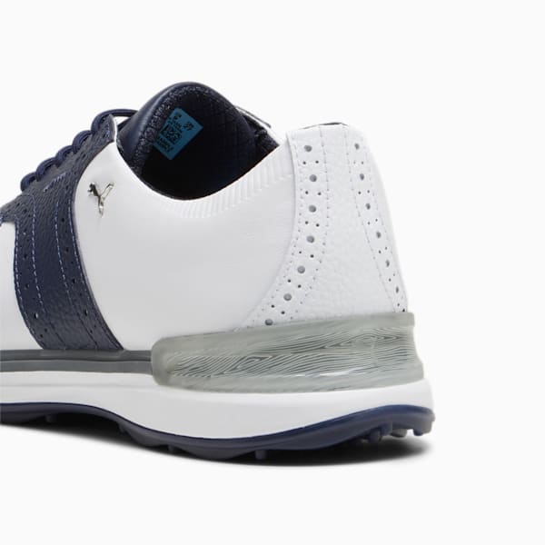 White PUMA golf shoe featuring navy accents and textured heel detail.