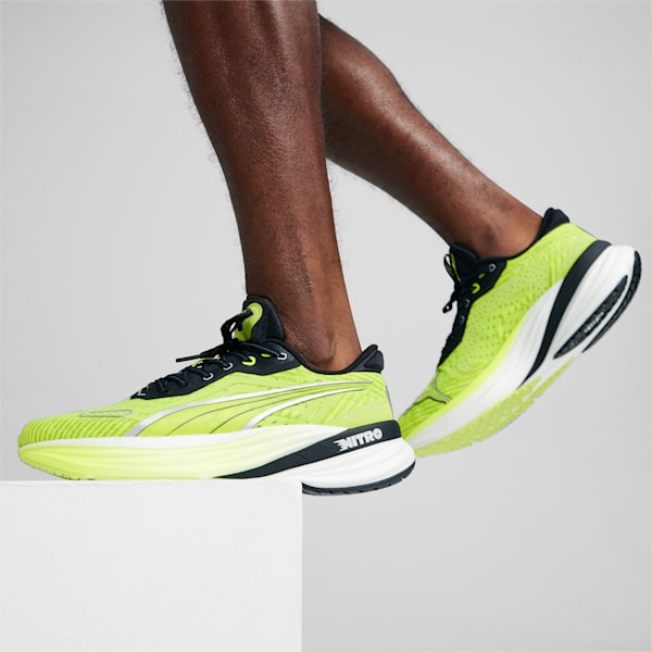 On grey, a model's legs wear neon running shoes with 'NITRO' on the side.