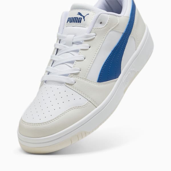 White PUMA unisex trainer with blue stripe and lace-up fastening.