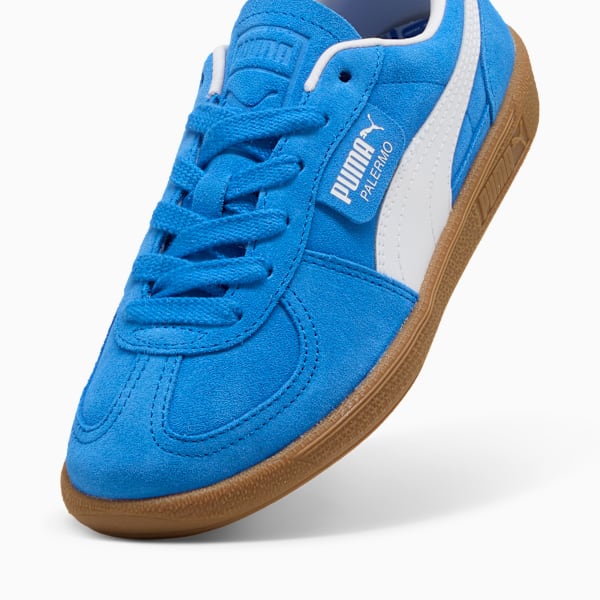 Blue PUMA Palermo trainers featuring a white stripe and brown sole.