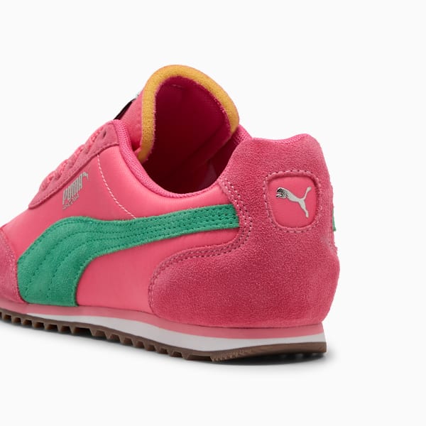 Pink PUMA trainers with a green stripe and yellow trim, seen from the rear.