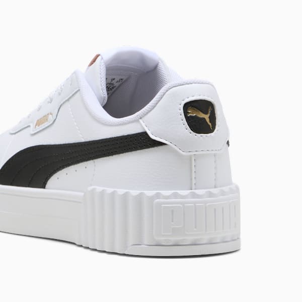 White PUMA trainer with black stripe, gold logo and ridged sole for women.