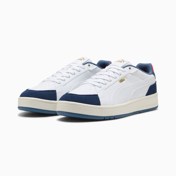 White PUMA trainers for adults with navy toe and light sole detailing.