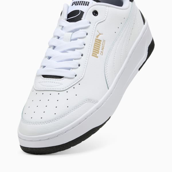 White PUMA trainer featuring lace-up closure and gold logo detail.