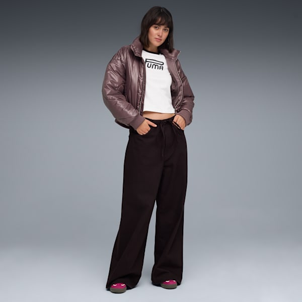 A model stands on a grey background wearing a jacket, top, trousers and shoes.