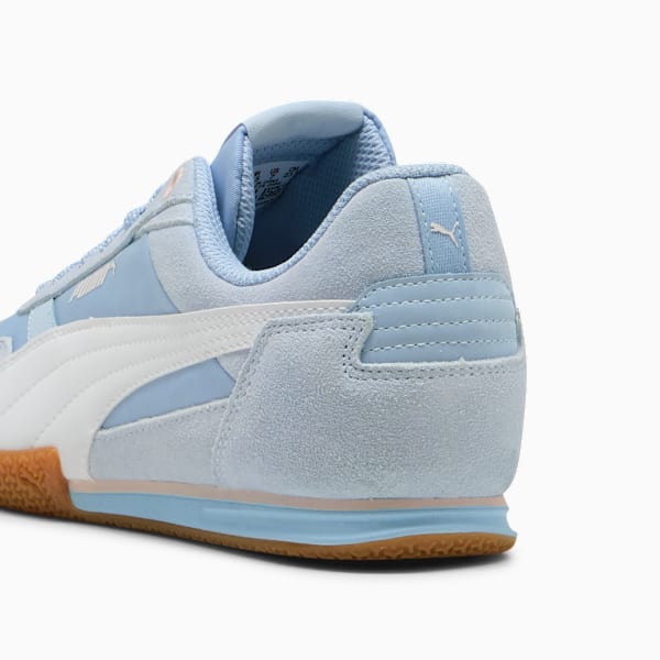 Light blue PUMA trainer shows a white side stripe and a gum-coloured sole.