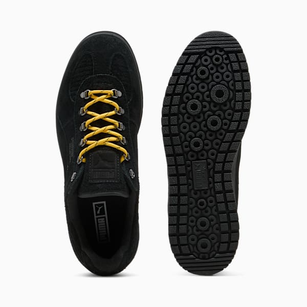 Black PUMA men's shoe with yellow laces and patterned black sole.