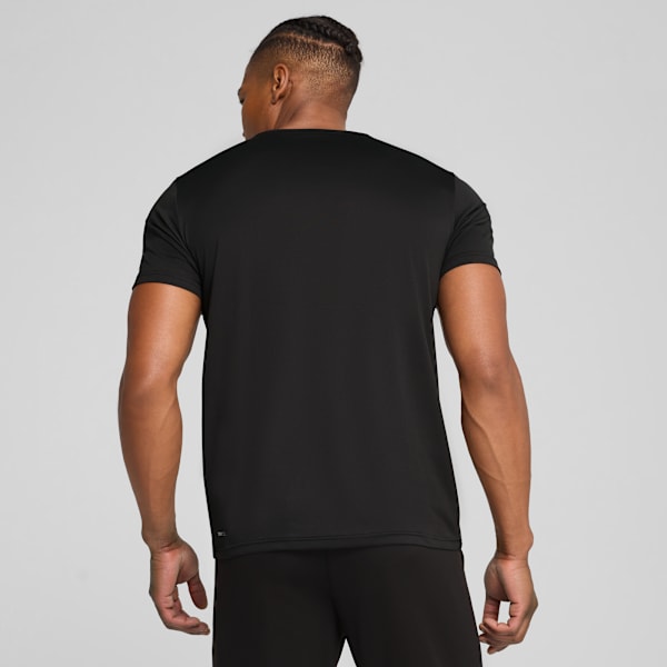 A model faces away from the camera against a grey backdrop, wearing a black t-shirt.