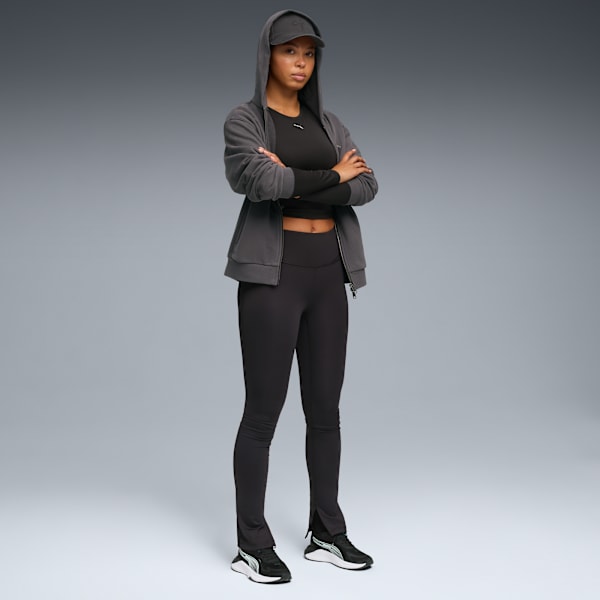 A model with crossed arms poses in activewear against a grey backdrop.