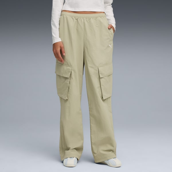 A model stands against grey wearing a white top, beige trousers with pockets, and trainers.