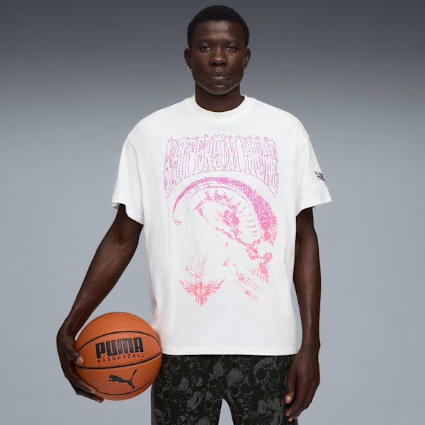 A model holds a basketball against a grey backdrop, wearing a graphic t-shirt.