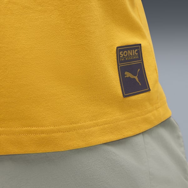 Close-up of a golden t-shirt with a Sonic the Hedgehog and Puma logo patch.