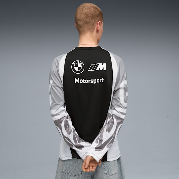 A model faces away, wearing a long-sleeved BMW Motorsport shirt against grey.