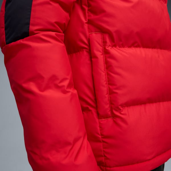 Close-up of a red puffer jacket with black shoulder detail and a pocket.