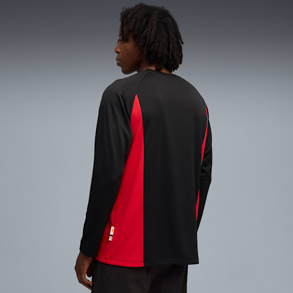 A model in a black and red long-sleeved shirt against a grey backdrop.