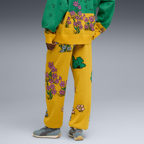Model shown against grey backdrop, wearing floral patterned yellow and green knitwear.