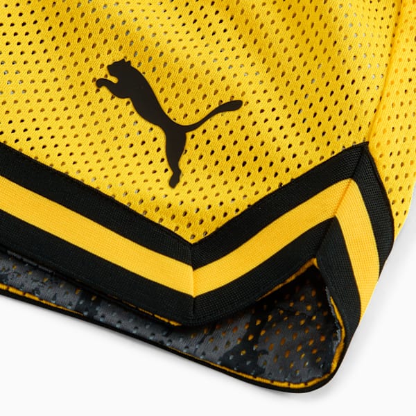 Yellow PUMA shorts show a black logo and black and yellow striped trim.