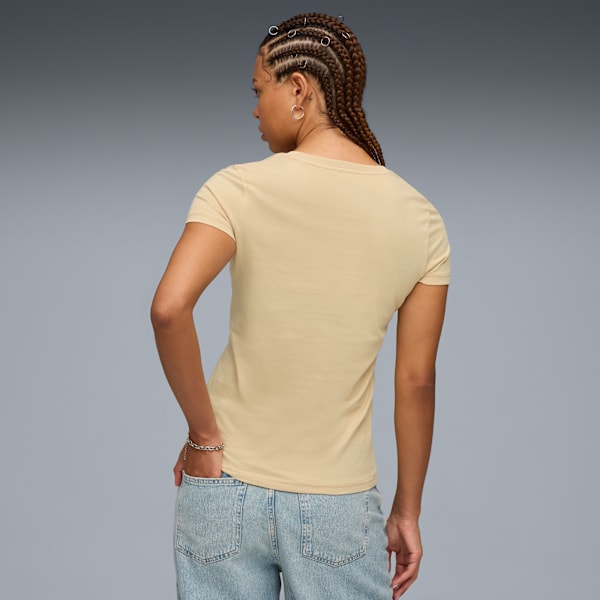 A model poses against grey wearing a tan t-shirt and jeans, seen from the back.