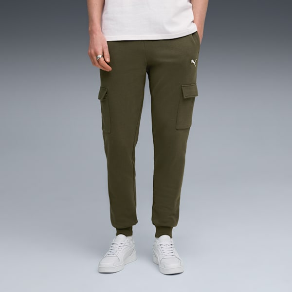 A model stands on grey wearing olive cargo trousers and white trainers.
