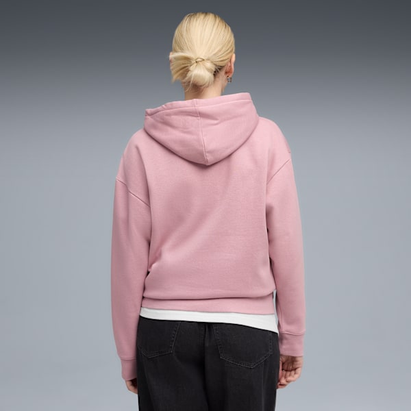 A model faces away on grey, wearing a pink hoodie, white t-shirt and dark jeans.