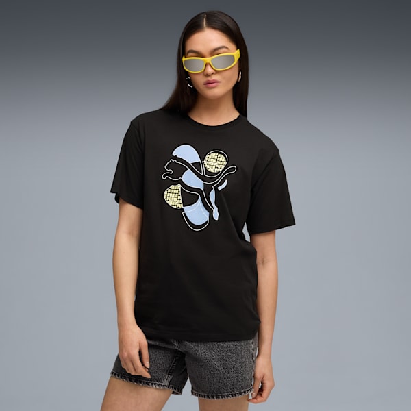 A model with yellow glasses wears a black t-shirt with a logo against a grey backdrop.