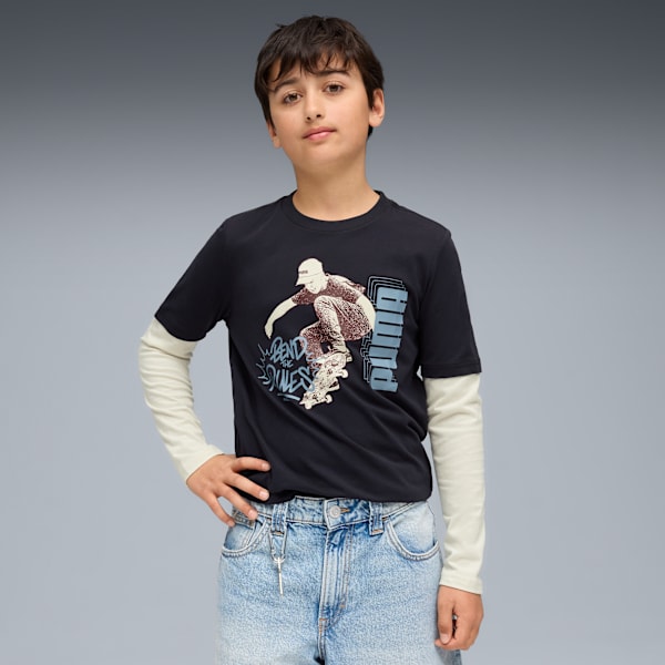 A model on a grey backdrop wears a black t-shirt with a skater design and light blue jeans.