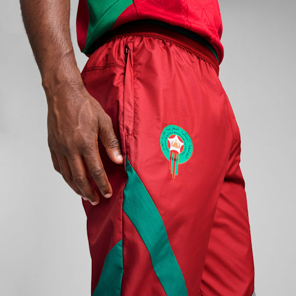 Close-up of a model in red Morocco-branded bottoms against a grey backdrop.