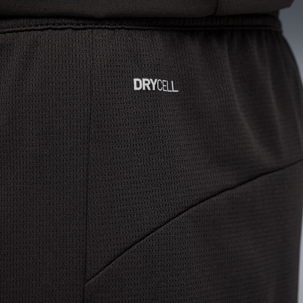 Close-up of black shorts with 'DRYCELL' text against a blurred grey background.