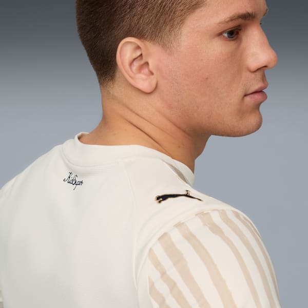 Profile of a model wearing a white and striped t-shirt against a grey backdrop.
