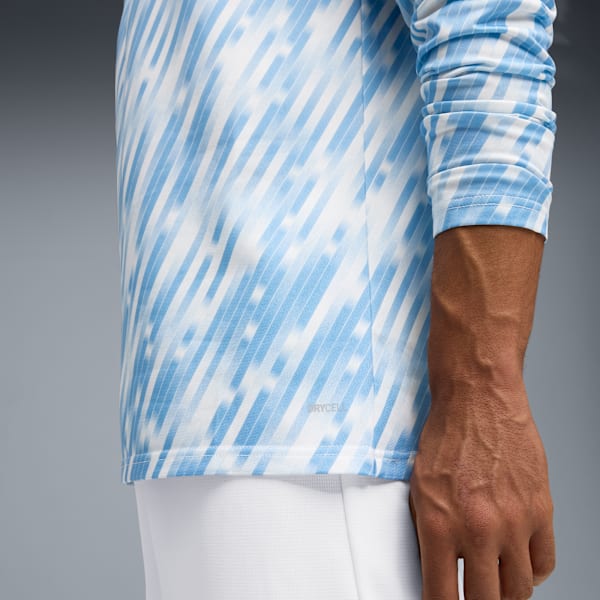 Against grey, a model wears a blue and white striped top with white bottoms.