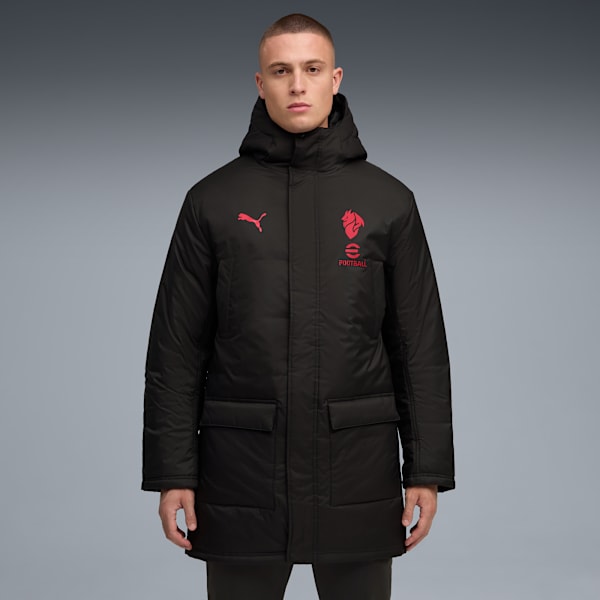 A model stands against a grey backdrop wearing a black hooded coat with red logos.