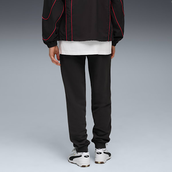 A model faces away on grey, wearing a jacket, t-shirt, track bottoms and trainers.