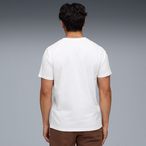 A model faces away on grey, wearing a white t-shirt and brown shorts.